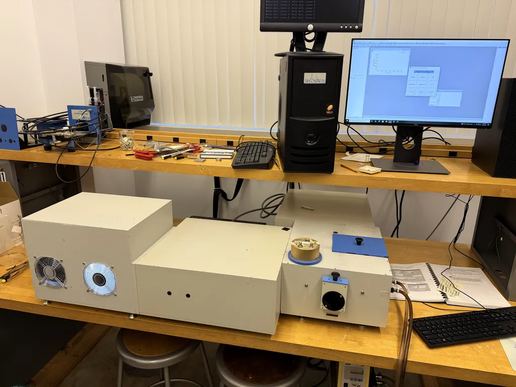 The Horiba Fluorolog spectrofluorometer on a lab bench, its control monitor on the shelf above.